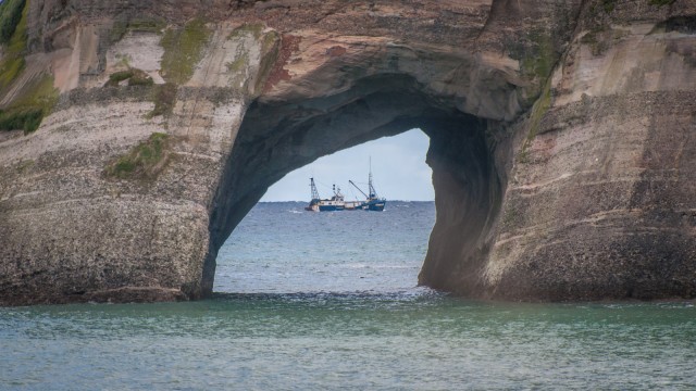 Perfect timing to catch the fishermen through the hole in the rock