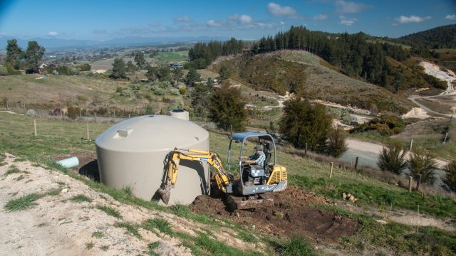 Finishing earth works around the extra water tank