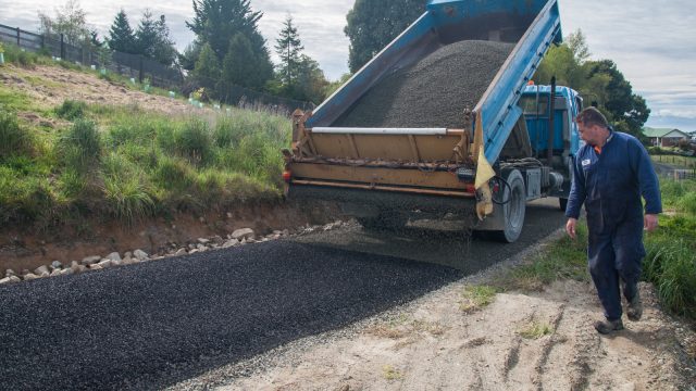 Adding a layer of fine gravel on top by driving in reverse up the hill. Look that that precision!